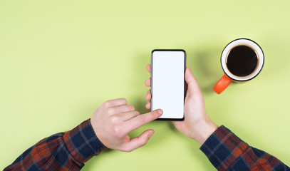 A Cup of coffee and a modern smartphone. White screen, you can insert your design.