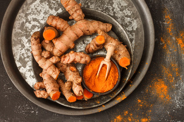 Turmeric root and turmeric powder on a white background