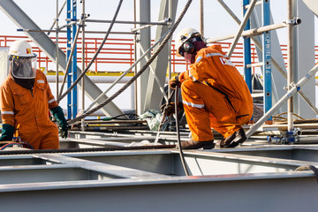 Offshore fitters preparing acetylene hoses for cutting tie-down od a structure prior to heavy lift