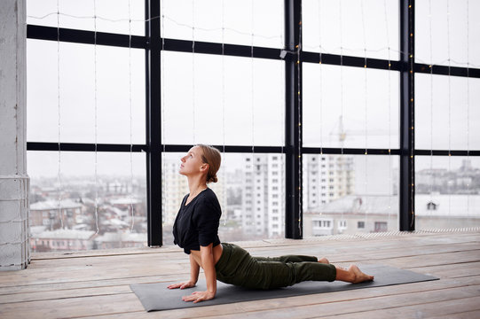 Beautiful young woman practices yoga asana Urdhva Mukha Svanasana - upward facing dog at the yoga class