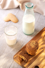 Oatmeal Cookies On A Wooden Board On A Sunny Day With A Glass And A Bottle Of Milk.