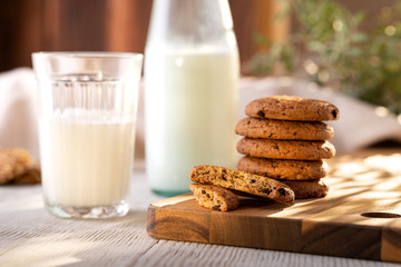 Oatmeal Cookies On A Wooden Board On A Sunny Day With A Glass And A Bottle Of Milk.