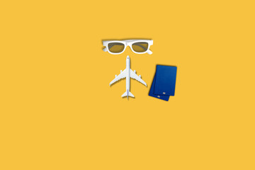 Flat lay design of travel concept with plane on yellow background with copy space.