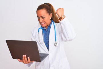 Middle age mature doctor woman holding computer laptop over isolated background annoyed and...