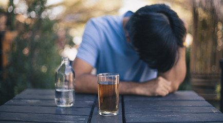 Drunk man drink alcohol and sleeping on a table