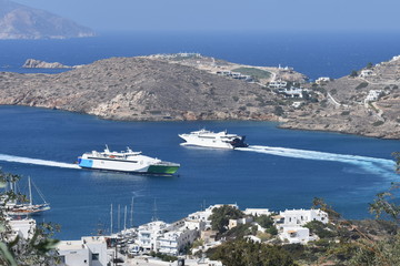 Greece, the island of Ios.  Two boats at the harbour of Yailos.  One arriving, one leaving.  Both ships are of the high speed type.  In the background is the island of Sikinos.