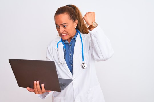 Middle Age Mature Doctor Woman Holding Computer Laptop Over Isolated Background Annoyed And Frustrated Shouting With Anger, Crazy And Yelling With Raised Hand, Anger Concept