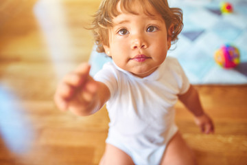 Beautiful toddler child girl playing on her knees on the floor