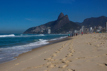 Fototapeta na wymiar The most popular and famous beach of Brazil and Rio de Janeiro - Ipanema and Copacobana, relaxing on the beach among the rocks, sand and palm trees. The famous beaches 