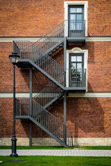 Black wrought iron staircase on red brick wall