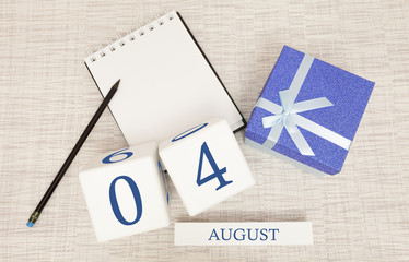 Calendar with trendy blue text and numbers for August 4 and a gift in a box.