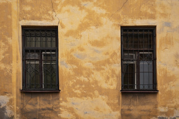 Two Windows on the yellow facade of the old house