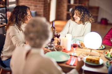 Beautiful group of women smiling happy and confident. Eating roasted turkey celebrating thanksgiving day at home