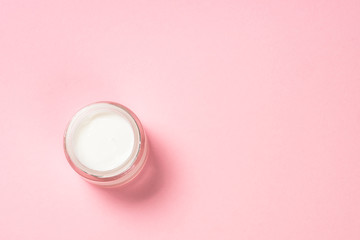 Cream for skin on pink top view.