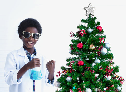 African mixed kids testing chemistry lab experiment and holding glass tube flask near Christmas tree in science classroom, white background - Powered by Adobe