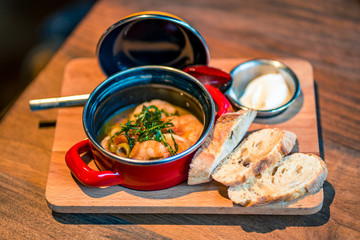 Garnelensuppe mit Brot und Dip im Topf