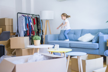 Beautiful toddler child girl jumping on the sofa