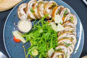 Meatloaf with cream sauce and greens, green leaves of lettuce, top view. Chicken roll flat lay