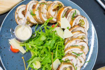 Meatloaf with cream sauce and greens, green leaves of lettuce, top view. Chicken roll flat lay