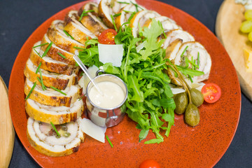 Meatloaf with cream sauce and greens, green leaves of lettuce, top view. Chicken roll flat lay
