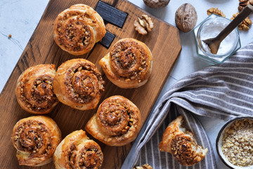 Snail buns with cinnamon and nuts on a concrete background.