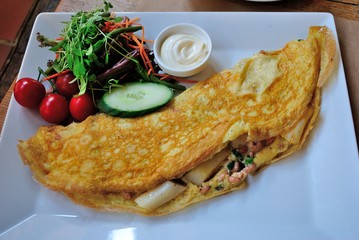 Belgian style omelette with asparagus and shrimps served with mayonnaise and fresh veggie salad
