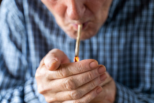 Senior man at home smoking marihuana joint