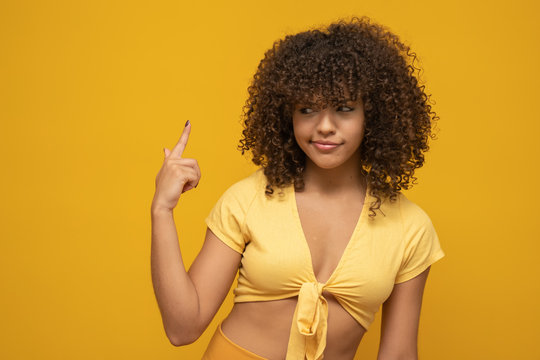 Are you out of your mind? Horizontal shot of handsome emotional Afro American woman fore finger at his temple. Making fun of crazy idea. Body language, signs and gestures.