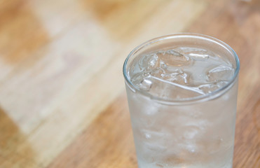 Ice cold water in glass on wooden table with copy space. Drink and healthy concept.