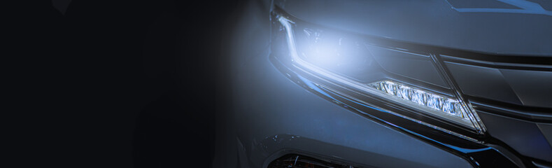 Obraz na płótnie Canvas Modern sport car headlight with flare on the road.