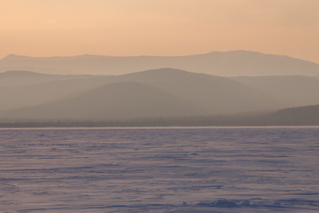 panorama winter mountain,misty hills mountain tops in pink dawn