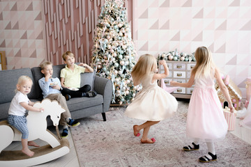 Two girls dancing in the living room while the boys watching them