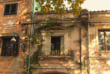 Classic wide-angle view of the facade of the abandoned building. Old windows with the wooden...