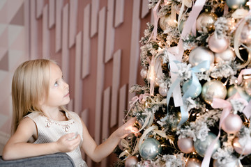 Blond little girl watching Christmas tree