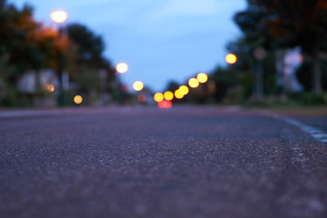 Straße in Dämmerung mit Lichtern und Fahrstreifen