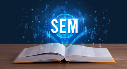 SEM inscription coming out from an open book, digital technology concept