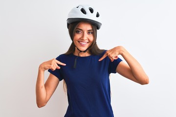 Young beautiful cyclist woman wearing security bike helmet over isolated white background looking...