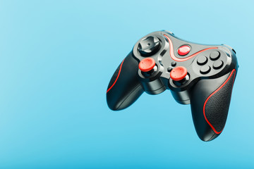 Black gamepad on a black red background, . Gaming concept. © Alexander