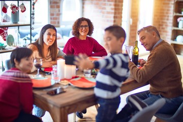 Beautiful family smiling happy and confident. Eating roasted turkey make selfie by smartphone celebrating christmas at home