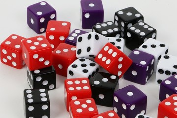 heap of colorful dices are lying in the white studio