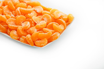 Juicy orange slices of MANDARIN in a rectangular white plate on a white background. Isolate.