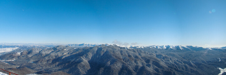 Fototapeta premium Sunny Winter Day With The Mountains Full Of Snow, Poiana Brasov, Romania, panorama