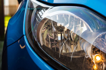 Vehicle headlight with the side light turned on.  Headlight surrounded by the metallic blue of the vehicle.