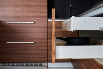 drawers in high-tech kitchen with facades made of walnut veneer