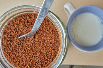 Soluble coffee pot, next to cup with milk