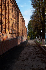 red brick wall. Shadows on the wall. Factory Sunny day. Autumn. Urban environment.