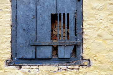 old blu wooden door in a yellow stone wall