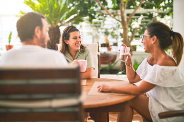 Beautiful family sitting on terrace drinking cup of coffee speaking and smiling