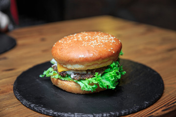 Burger with lettuce on a dark plate
