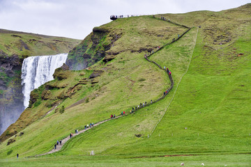 Campsite next to the Skógafoss waterfall in Iceland, Summer. Sunny day with some clouds. Some...